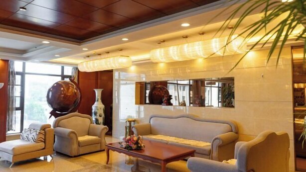 A lobby with a sofa, chairs, a coffee table, and a large vase. - Qingtian Boutique Hotel (Zhaotong Fengxia Road) (Zhaotong)