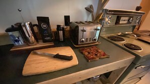 Eine Küchenarbeitsplatte mit einem Toaster, einer Kaffeemaschine und einem Schneidebrett mit einem Messer.