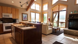 A spacious kitchen with a central island, wooden cabinets, and large windows. - Mountain-View Condo in Dillon • Walk to Dining & Lake • Close to Keystone (Dillon)