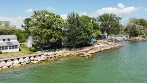 A riverside property with a dock, stone walls, and houses with blue roofs.
