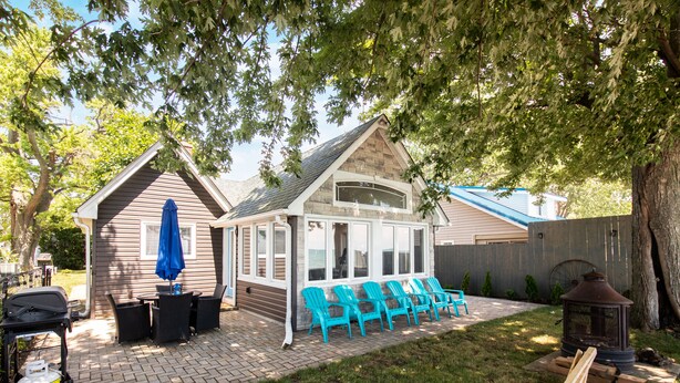 A backyard with a barbecue area, outdoor seating, and a wooden deck.