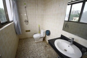 A bathroom with a toilet, sink, and shower.