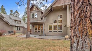 A two-story house with a large front porch and a stone foundation. - Elegant, sleep 8, private hot tub, gourmet kitchen (Sunriver)