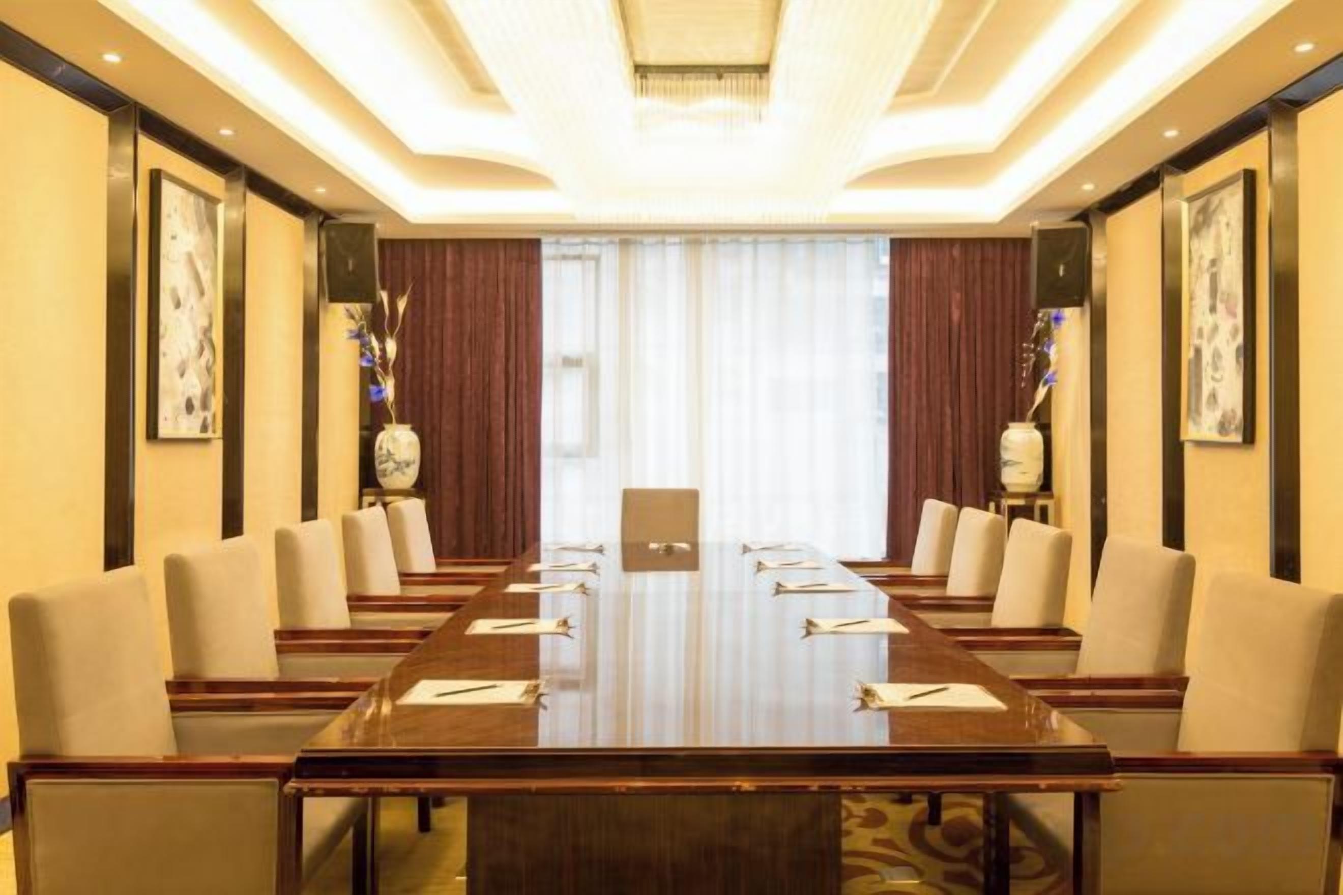 A conference room with a long table, chairs, and a chandelier.