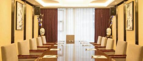 A conference room with a long table, chairs, and a chandelier.