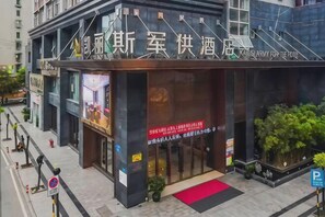 A hotel entrance with a red carpet, signage, and a small garden area. - Kailisi Army for the Hotel (Zunyi)
