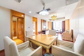A hotel room with a wooden dining table, four chairs, a ceiling fan, and a modern chandelier. - Kailisi Army for the Hotel (Zunyi)