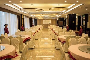 A banquet hall with round tables, chairs, and a long table down the center. - Kailisi Army for the Hotel (Zunyi)