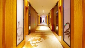 Un pasillo de hotel con paneles de madera y obras de arte enmarcadas en las paredes.