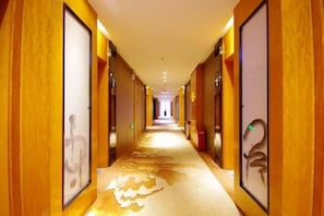 A hotel hallway with wooden paneling and framed artwork on the walls. - Kailisi Army for the Hotel (Zunyi)