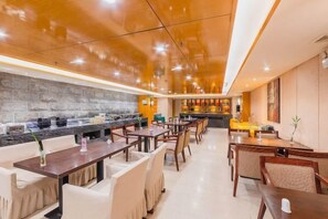 A modern restaurant with a long counter, multiple seating areas, and a bar in the background. - Kailisi Army for the Hotel (Zunyi)