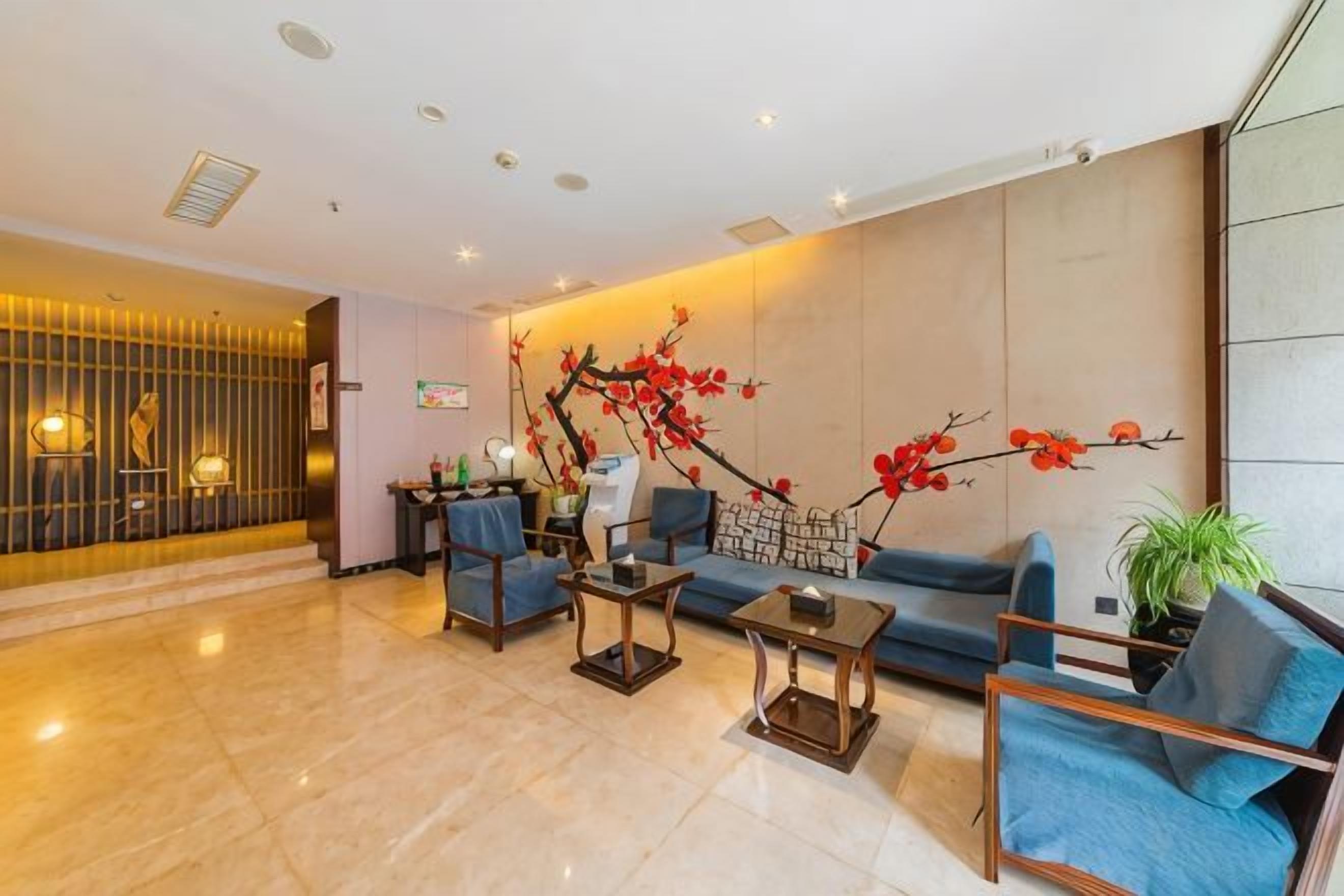 Um lobby moderno com balcão de recepção, área de estar e parede decorativa.