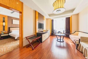 A hotel room with a bed, a desk with a TV, a dining table, and a sofa. - Kailisi Army for the Hotel (Zunyi)