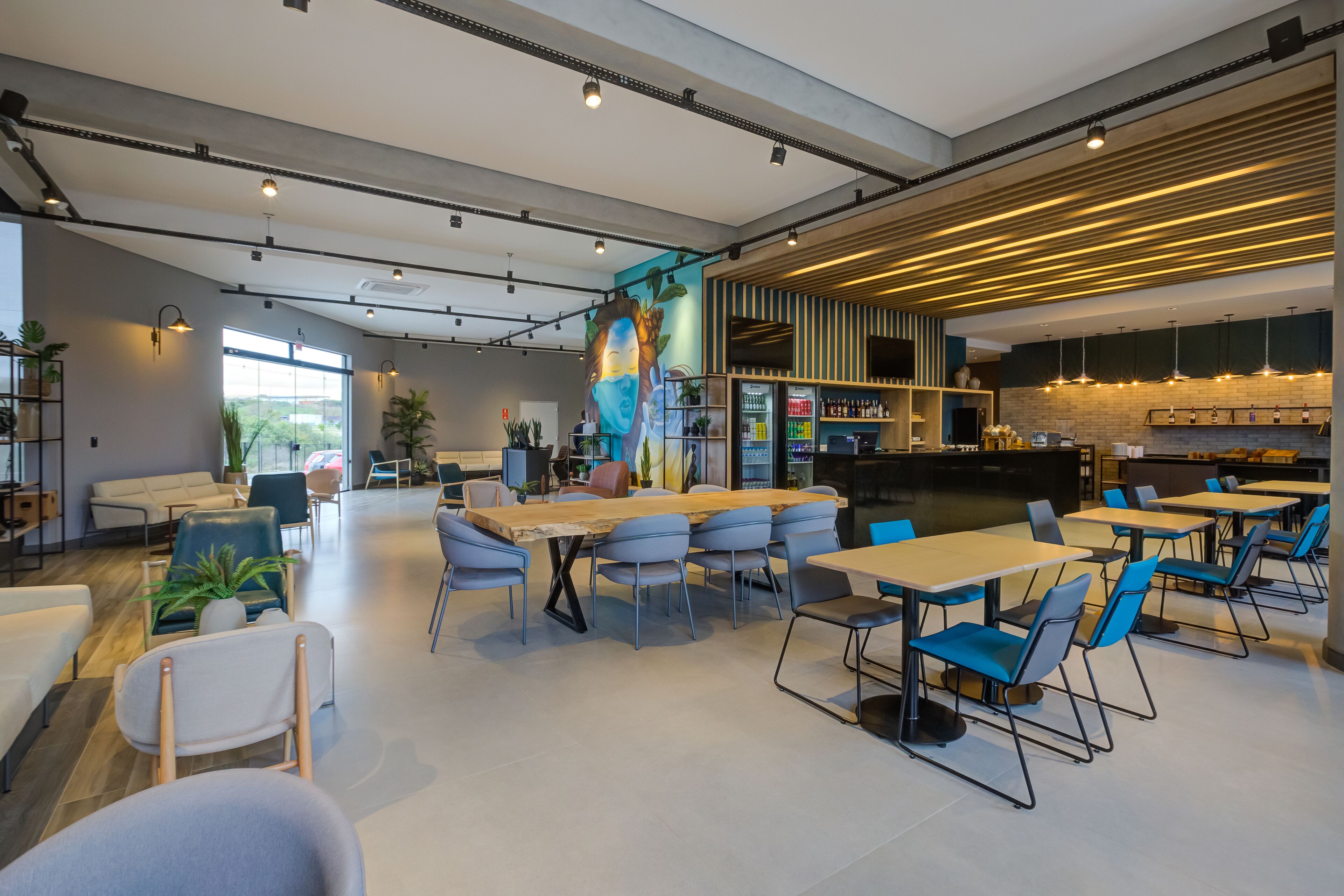 A modern cafe with tables and chairs, a bar area, and a kitchen in the background.