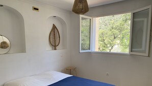 Ein Schlafzimmer mit einem Bett, einem Fenster und einer Wanddekoration in Form eines Blattes.