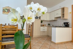 Una cocina con armarios blancos, una mesa de comedor de madera y una silla.