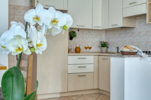 Una cocina moderna con armarios de madera clara, un salpicadero azulejado y una isla central con una cesta.