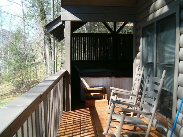 Enjoy the serene forest views from the deck, which features a bench and two chairs.