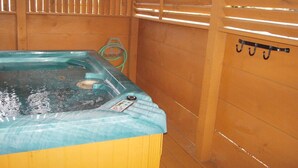A wooden spa room with a hot tub and a towel rack. - Countryside in Country Pines (Sevierville)