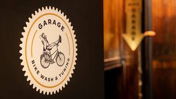 Ein Logo mit einem Fahrrad und dem Text 'Garage Bike Wash & Tuning' vor dunklem Hintergrund.