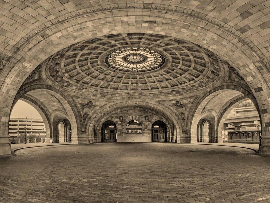 A large, open, arched interior space with a central circular skylight and multiple arches supporting the ceiling.