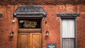 A brick building with a wooden door labeled "Southside Traveler's Rest." - Traveler's Rest Hotel (Pittsburgh)