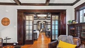 A spacious room with a wooden floor, a leather sofa with a yellow pillow, and a dining area with a table and chairs. - This gem sits in the heart of picturesque South Frankfort, near the Kentucky river (Frankfort)
