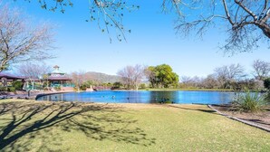 A swimming pool with a gazebo, trees, and a distant mountain. - NEW! Cozy desert getaway with private backyard and seasonal pool! (New River)
