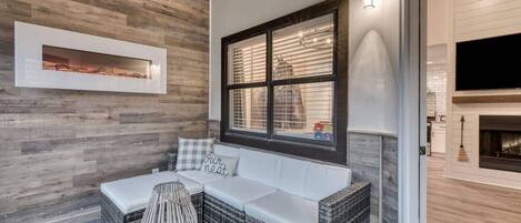 A cozy seating area with a cushioned bench, a woven side table, and a framed picture on the wall.