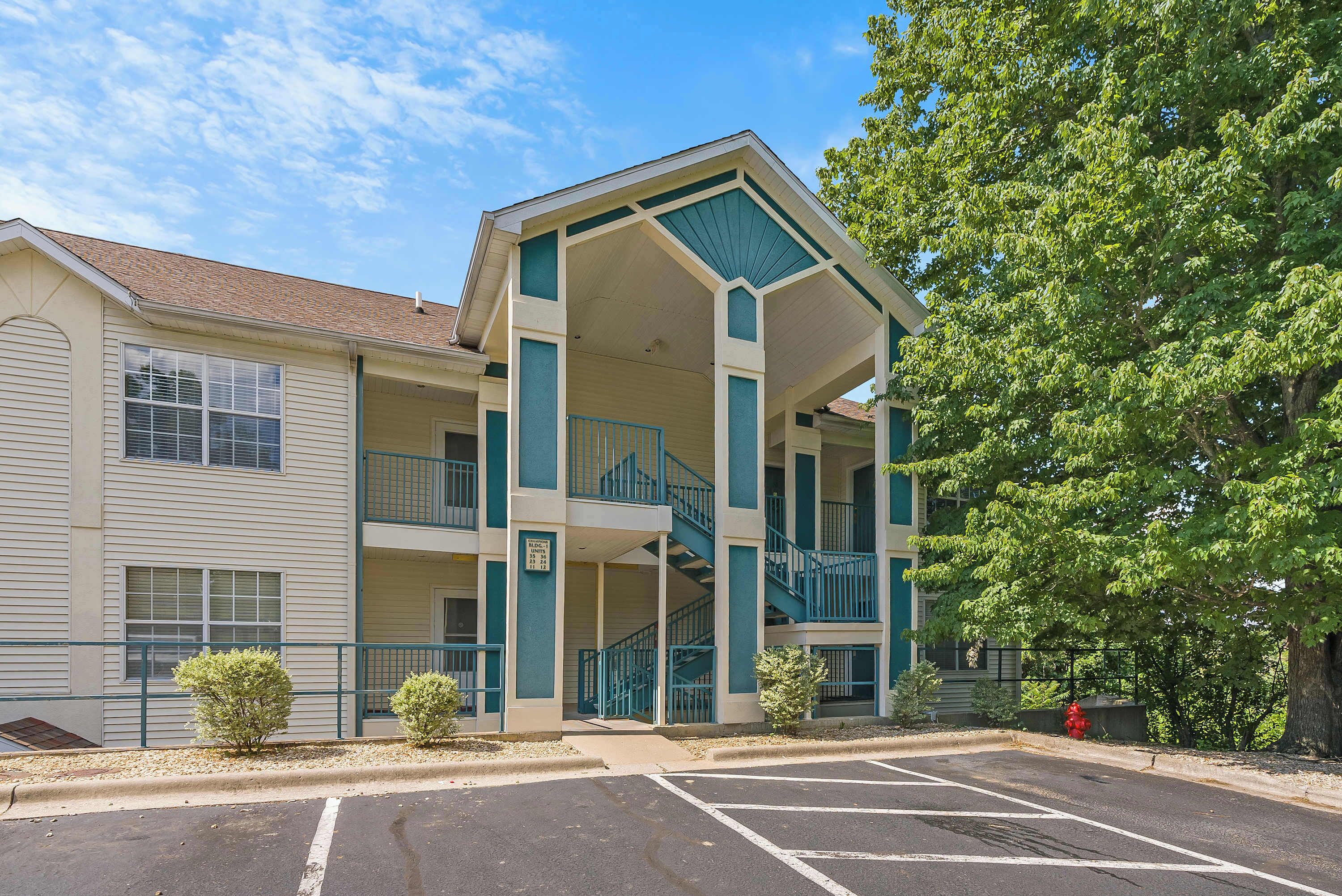 A multi-story building with a covered entrance and a staircase leading to the upper floors.