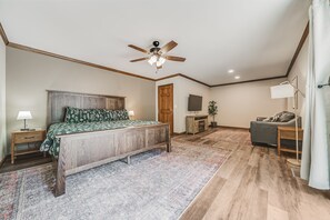 A bedroom with a wooden bed, a ceiling fan, a television, a desk, and a chair. - Deer Run Manor - Indoor Pool, Hot Tub & Game Room (Rockbridge)