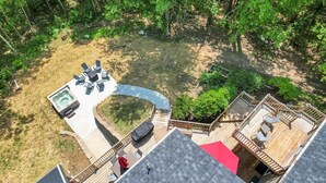 Een terras op het dak met een jacuzzi, zitgedeelte en een terras met houten balustrade.