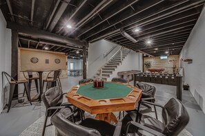 Quarto com mesa de bilhar, dardos e mesa de futebol de mesa.