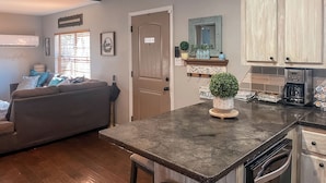 A modern kitchen with a built-in oven, a coffee maker, and a countertop with a potted plant. - Wister Ridge Cottage • Sleeps 10 • 3 Minutes to Wister Lake! (Wister)
