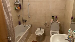 Un baño con bañera, bidé, inodoro y lavamanos.