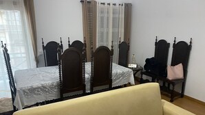 Un dormitorio con cama con dosel, una mesita con una estatua y una silla con un bolso.