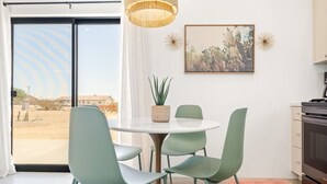 Et moderne køkken med spiseplads, et stort vindue og en kaktus.