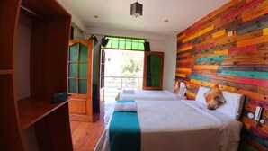 A room with two beds, a wooden wardrobe, and a colorful wooden wall. - Sumaq Wari Hotel (Ayacucho)