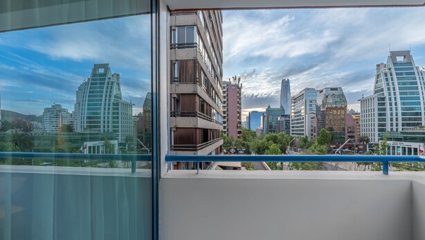 A cityscape view from a balcony with modern buildings and a clear sky. - Apart Hotel Elite  (Santiago)