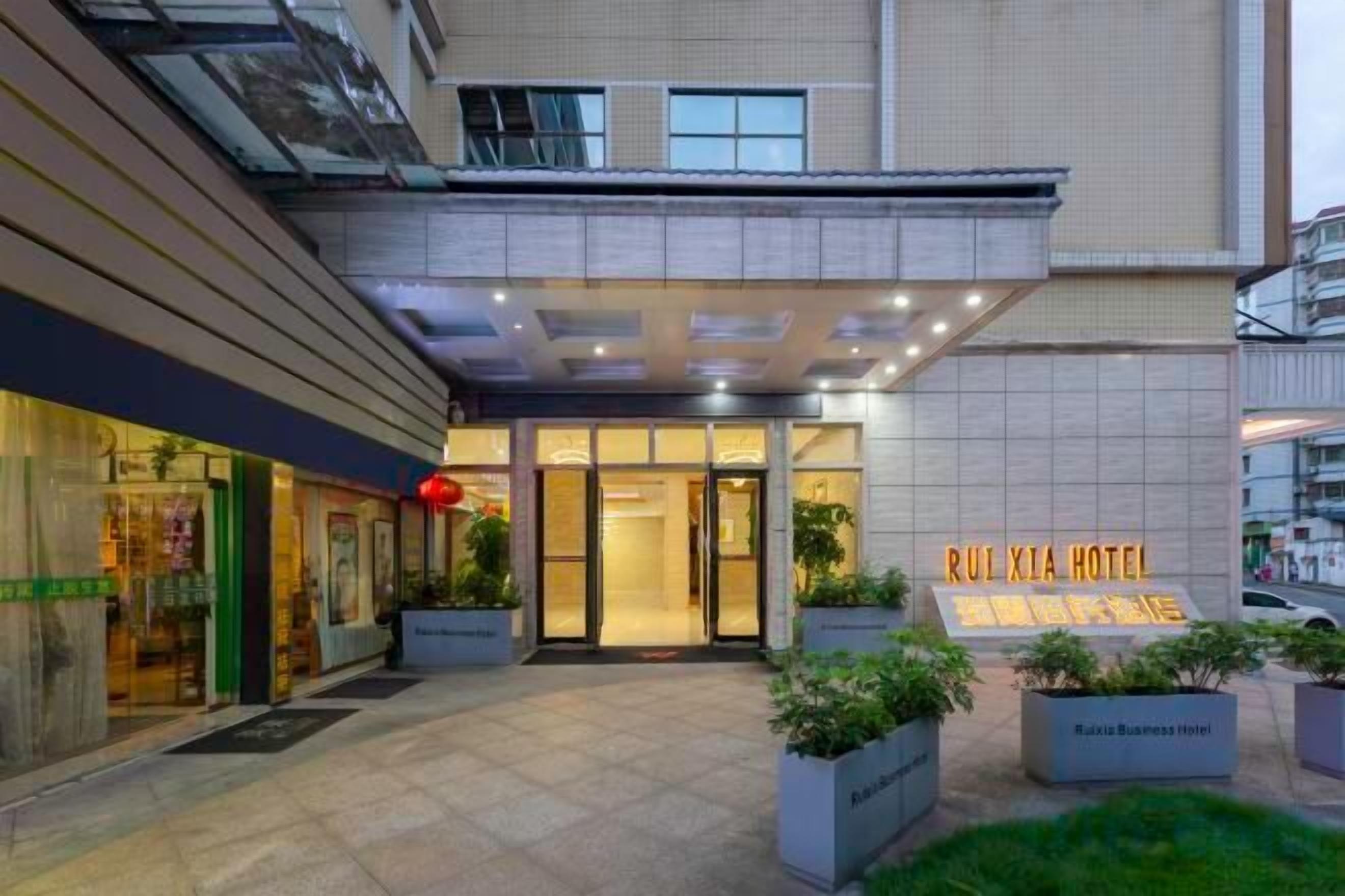 A hotel entrance with a sign reading 'RUI XIA HOTEL' and a visible entrance door.