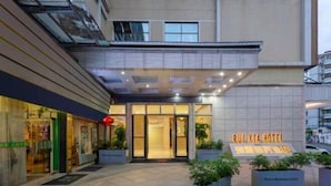 L’extérieur de l’hôtel RUI XIA présente une façade moderne, une grande entrée vitrée et des plantes en pot à l’avant.