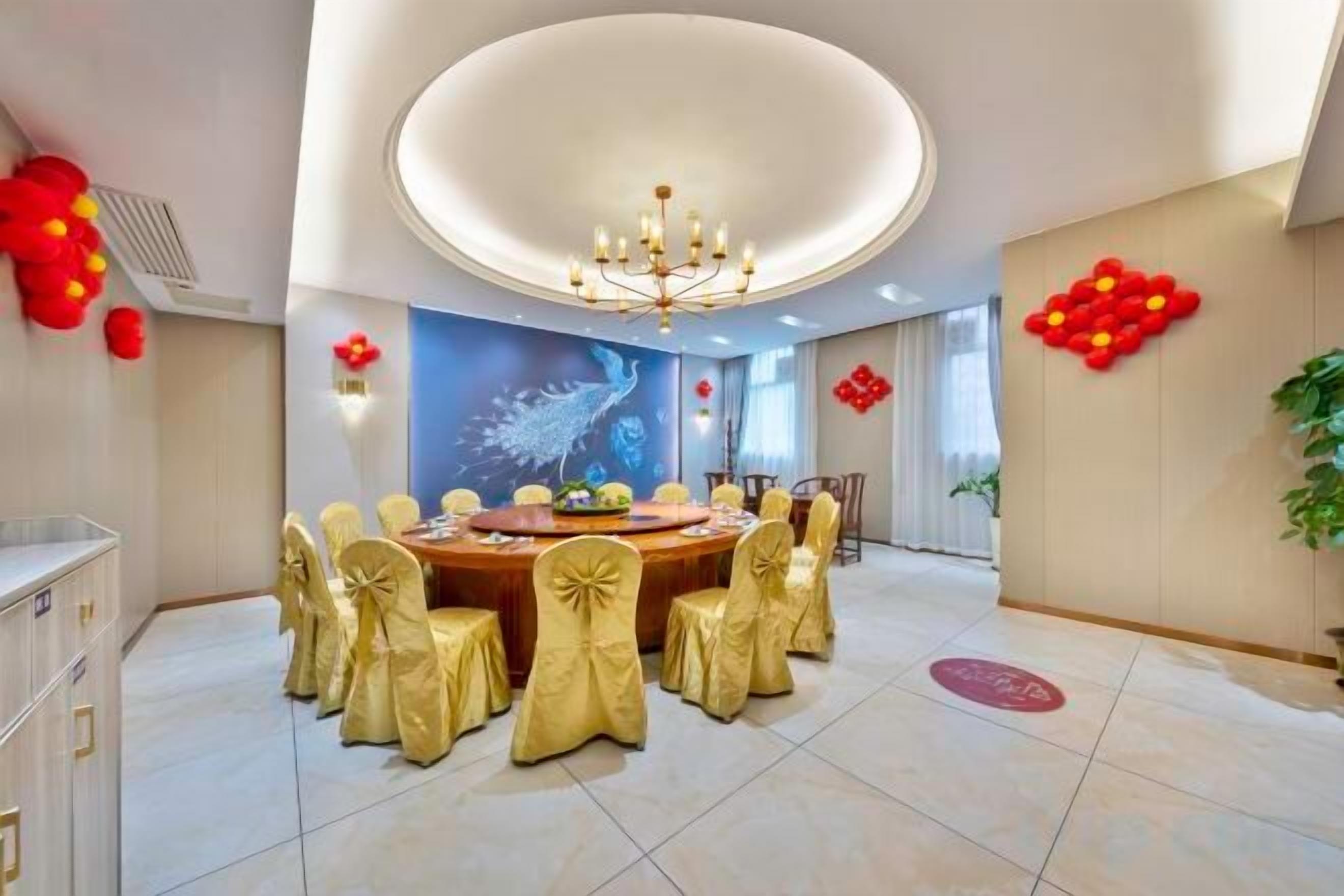 A dining area with a round table, chairs, and a chandelier.