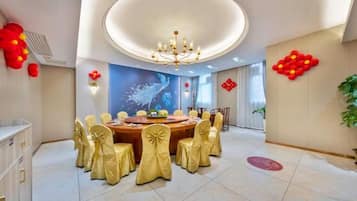 A dining area with a round table, chairs, and a chandelier.