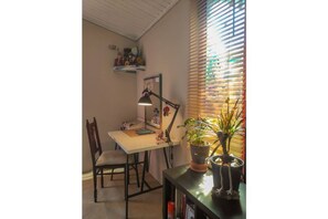 Une salle d’étude équipée d’un bureau, d’une chaise, d’une lampe et de plantes en pot.