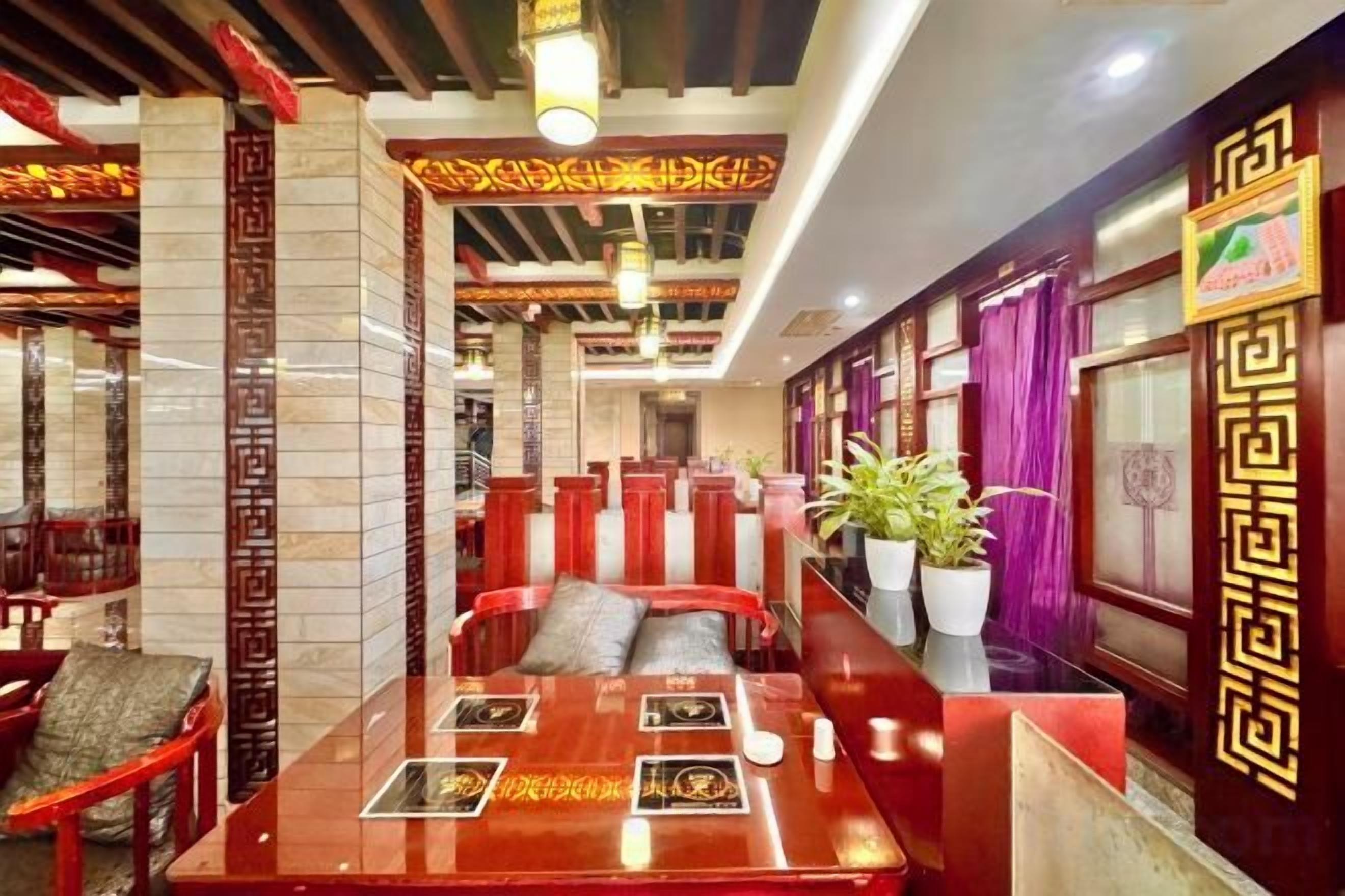 A restaurant interior with high tables, red cushioned booths, and traditional decor.