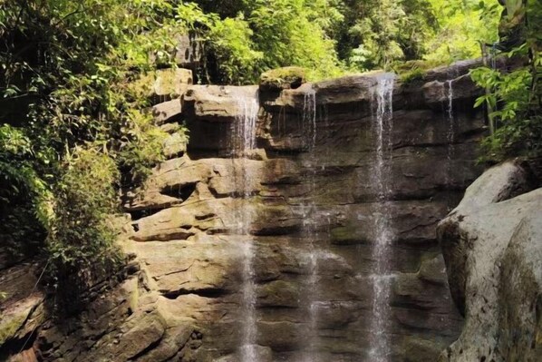 A natural rock formation with a waterfall. - Yongshun Minzu Hotel (Yongshun)