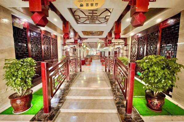 A hotel corridor with a marble floor, red railings, and potted plants. - Yongshun Minzu Hotel (Yongshun)