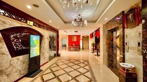 A hotel lobby with a marble floor, a chandelier, and a reception desk. - Yongshun Minzu Hotel (Yongshun)