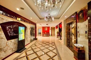 A hotel lobby with a marble floor, a chandelier, and a reception desk. - Yongshun Minzu Hotel (Yongshun)
