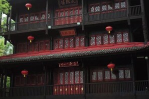 A traditional building with multiple balconies, red lanterns, and decorative wooden lattice windows.